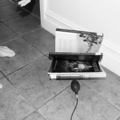A black and white image of a book on the floor by Jordan Ridout
