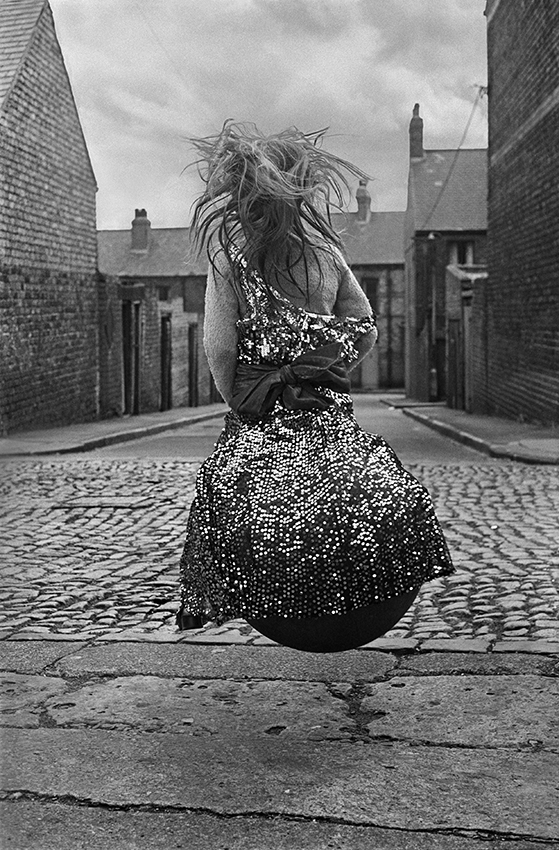 A girl in a sparkly party dress bounces on a Spacehopper